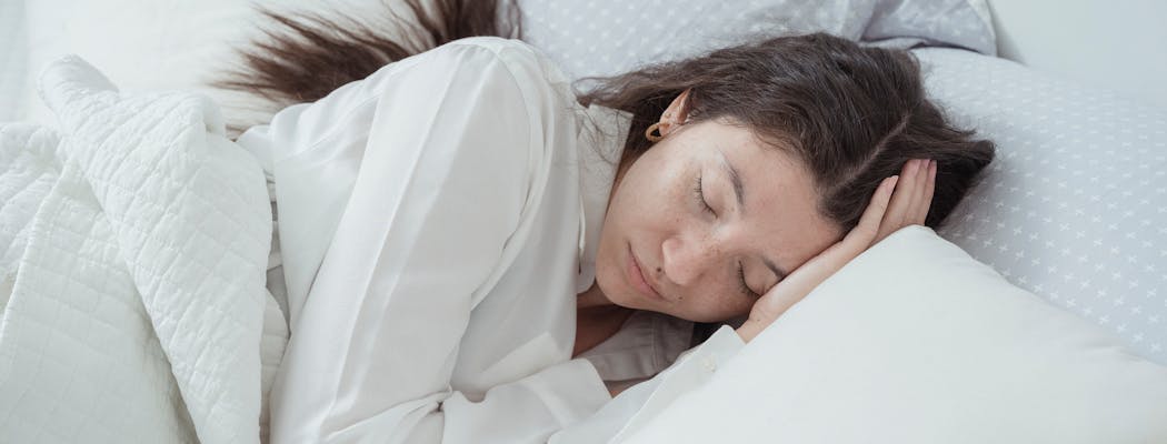 A woman sleeping after learning that quality sleep is one of the core self care tips for women balancing multiple roles