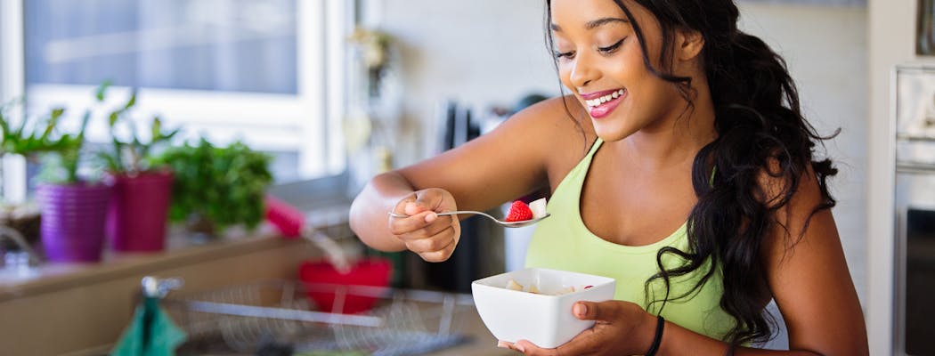 A woman eating healthy snacks, which is one of the most useful self care tips for women
